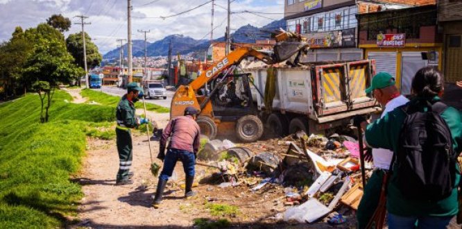 Operarios realizan jornada de limpieza con apoyo de maquinaria, recolectando residuos y escombros en espacio público del sector.