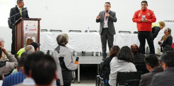 Encuentro institucional con participación de la comunidad y representantes en el escenario.