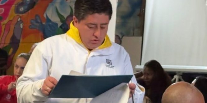Imagen alcaldía San Cristóbal Un funcionario de la Alcaldía Local de San Cristóbal lee un documento durante una reunión de trabajo con la comunidad en un espacio institucional.