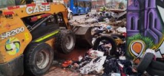 Maquinaria realiza recolección de residuos acumulados en espacio público durante jornada de recuperación ambiental.